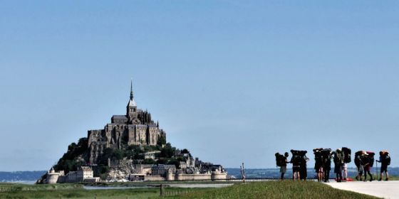 Poutníci před Mont Saint-Michel v Normandii.